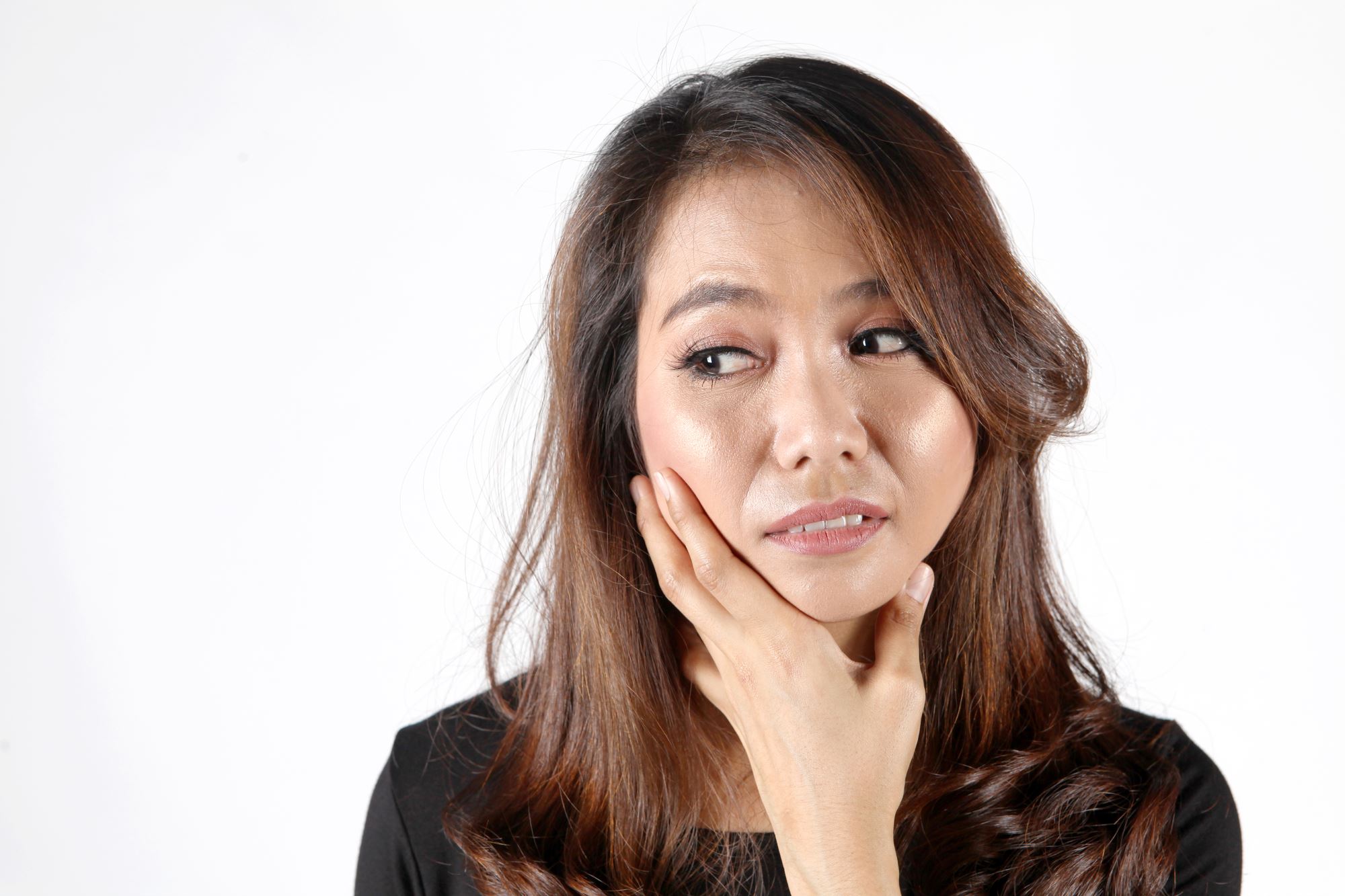 Asian woman with long hair with hand on jaw