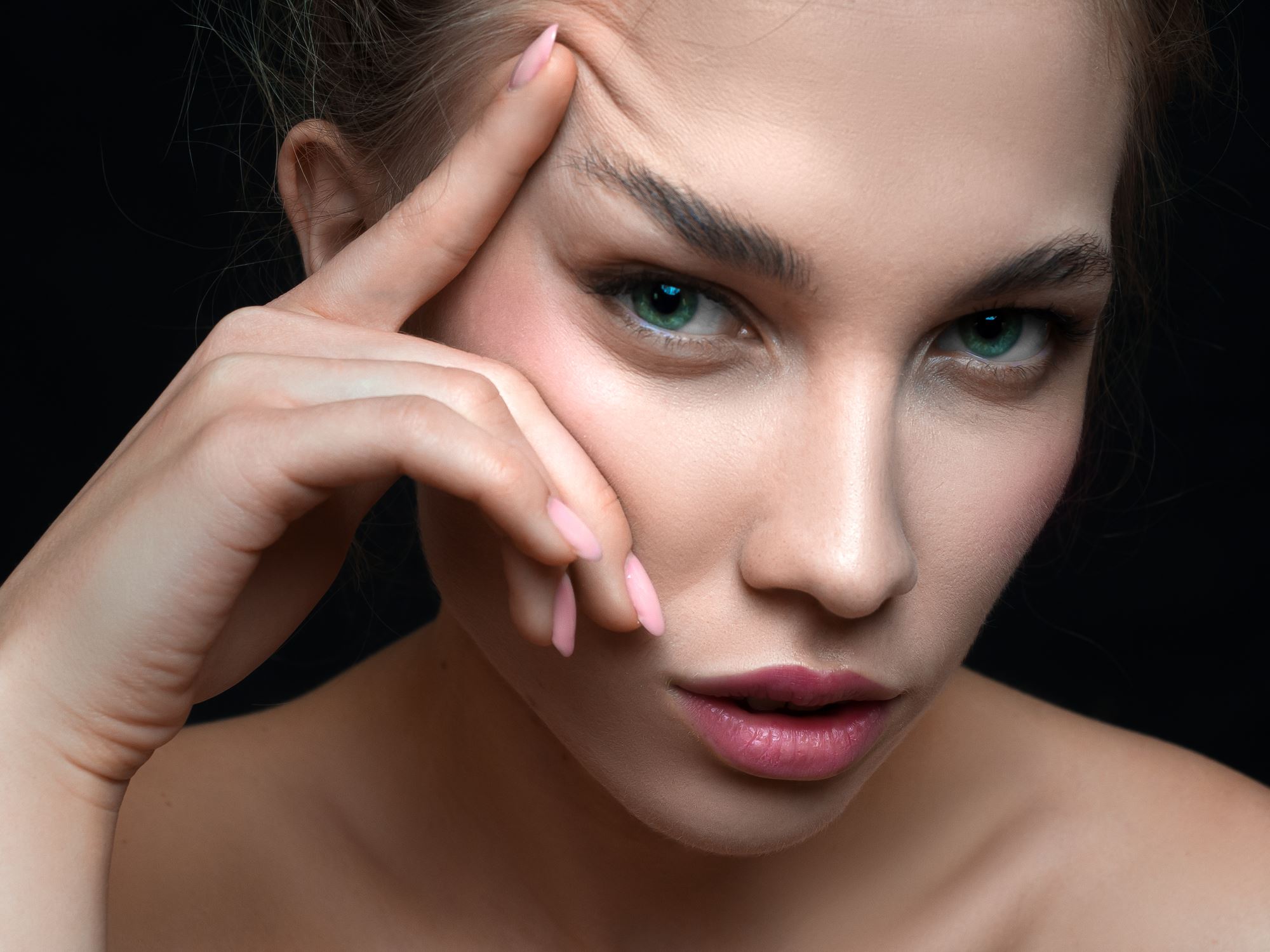 close up portrait of woman with blue eyes positioning eyebrow for brow lift