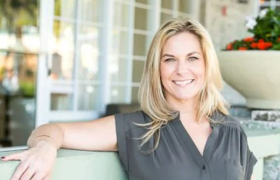 blonde woman sitting outside smiling