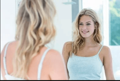 woman looking at herself in mirror