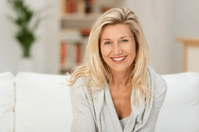 blonde woman sitting inside smiling